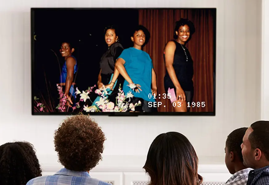 Family watching digitized home video on a television