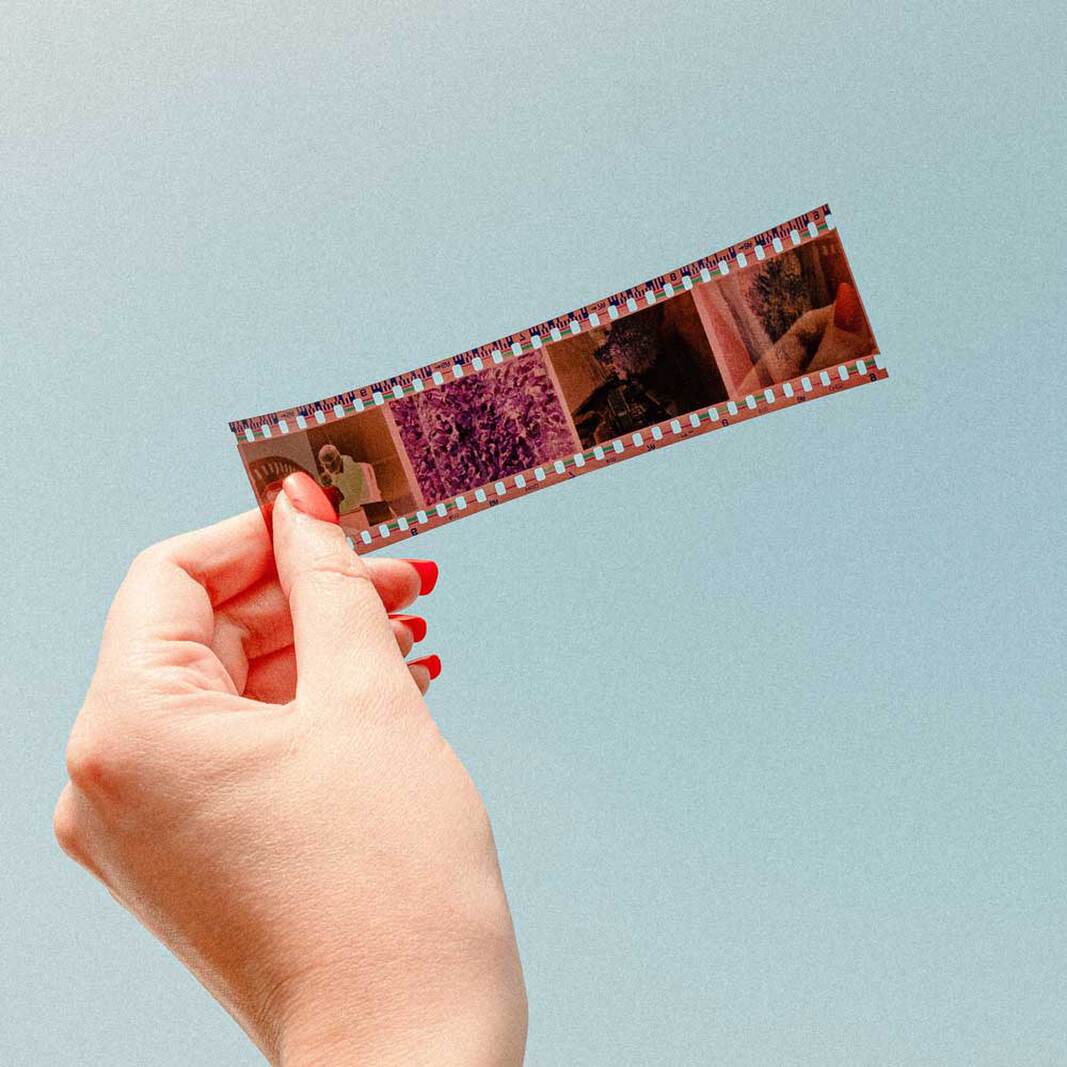 Hand holding a strip of developed photographic film negatives
