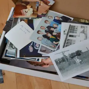 Stack of family photos, prints, and keepsakes gathered together for photo archiving and organization