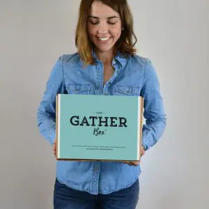 Person holding a teal Gather archival storage box used for organizing and preserving photos and memorabilia