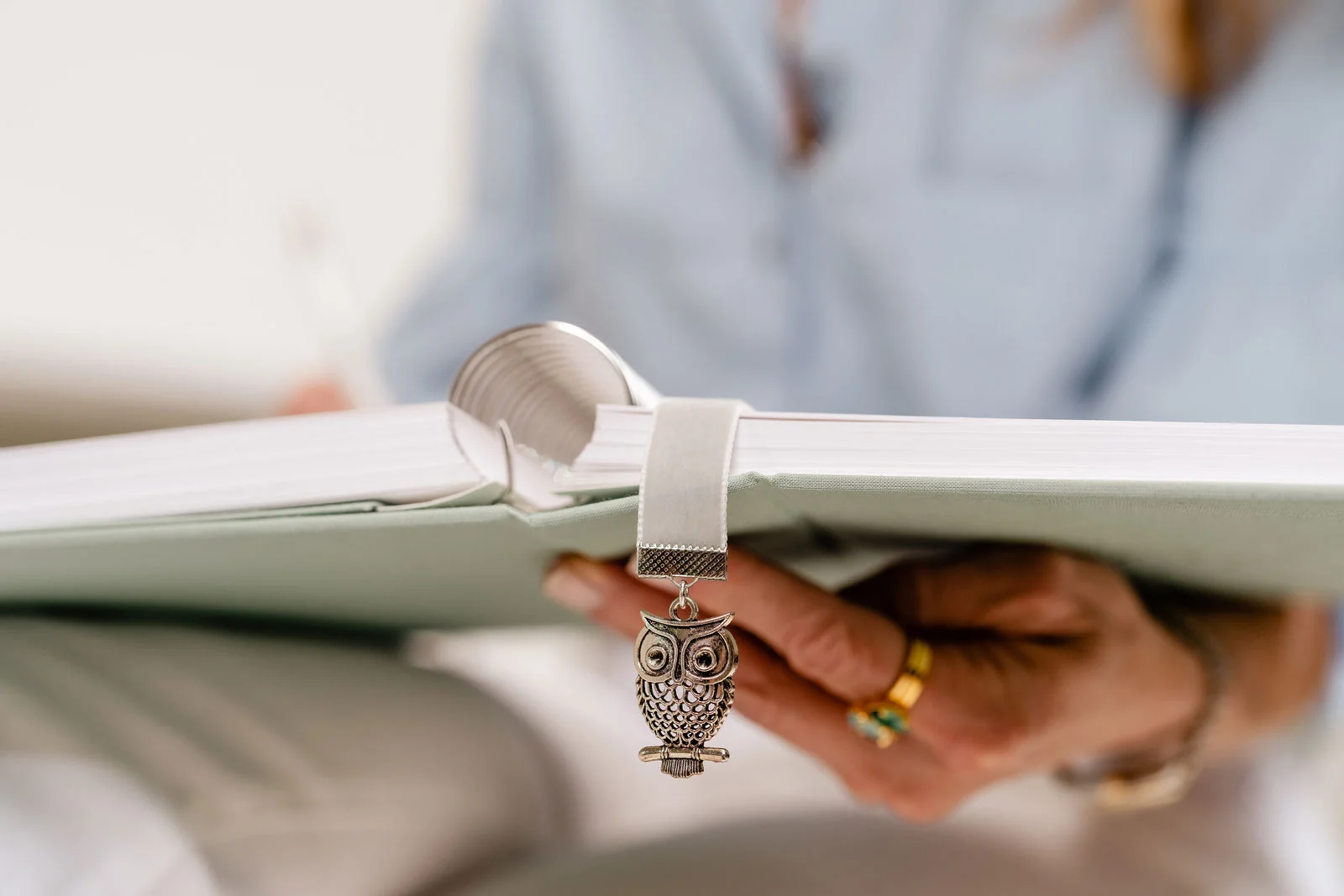 Women holds Dutch and Deckle Tuscany colored linen planner with Silver Owl Velvet Bookmark and Charm