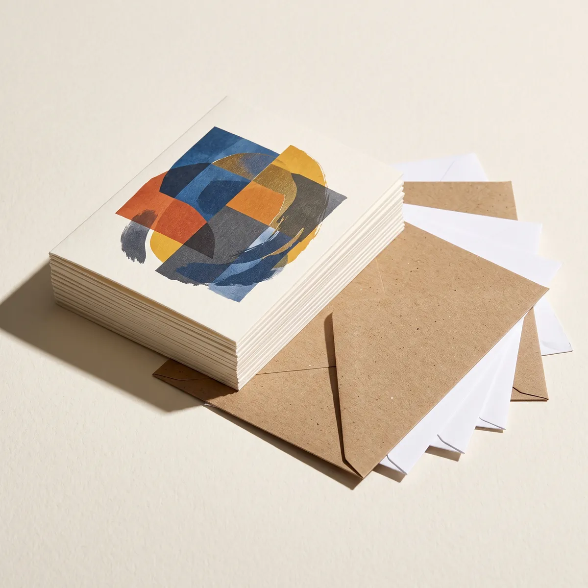 Stack of printed greeting cards with kraft and white envelopes fanned beside them.