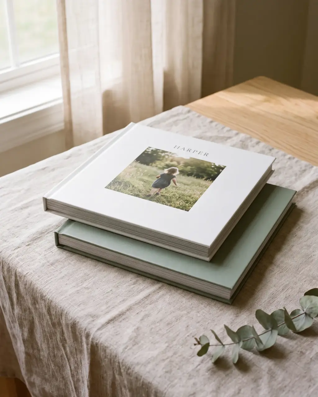 Two slim square layflat albums on linen