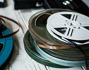 Vintage home movie reels ready for professional film transfer at The Camera Shop in St. Cloud, MN