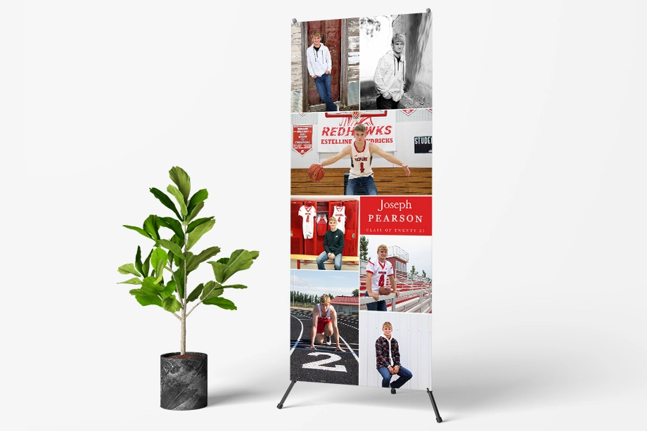 A large custom graduation banner with multiple photos displayed on a stand