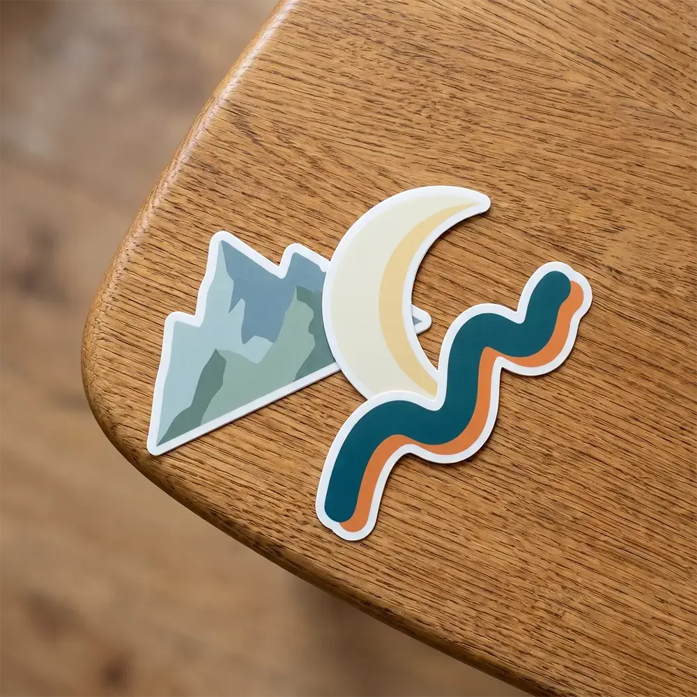 3 die cut vinyl stickers sitting on a table