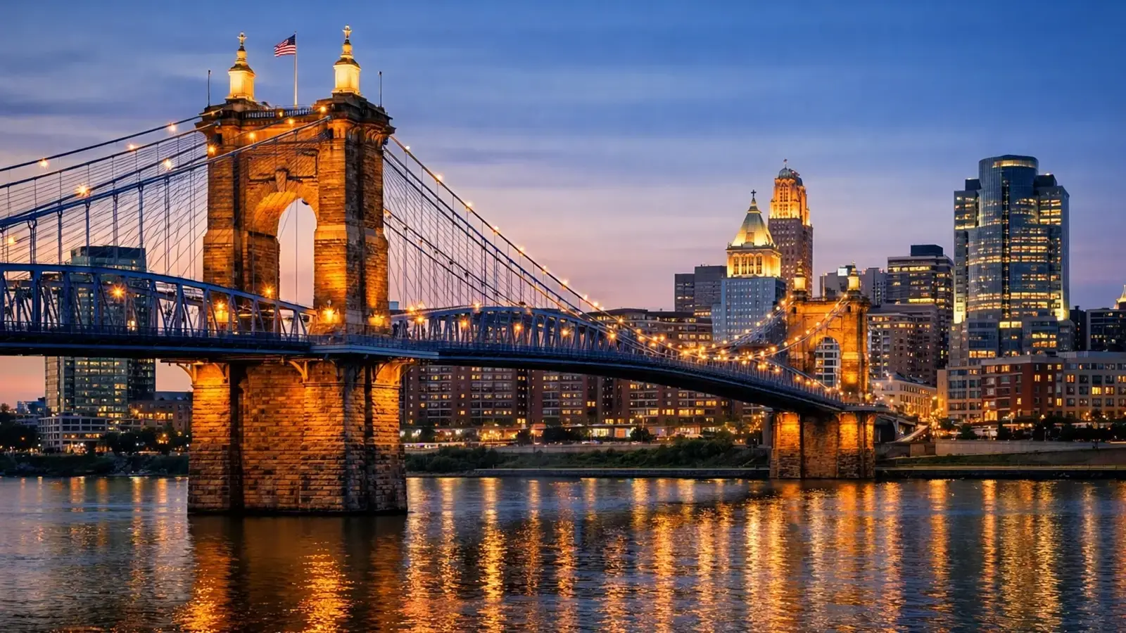 Roebling Suspension Bridge and Covington riverfront skyline representing service to Covington, Kentucky
