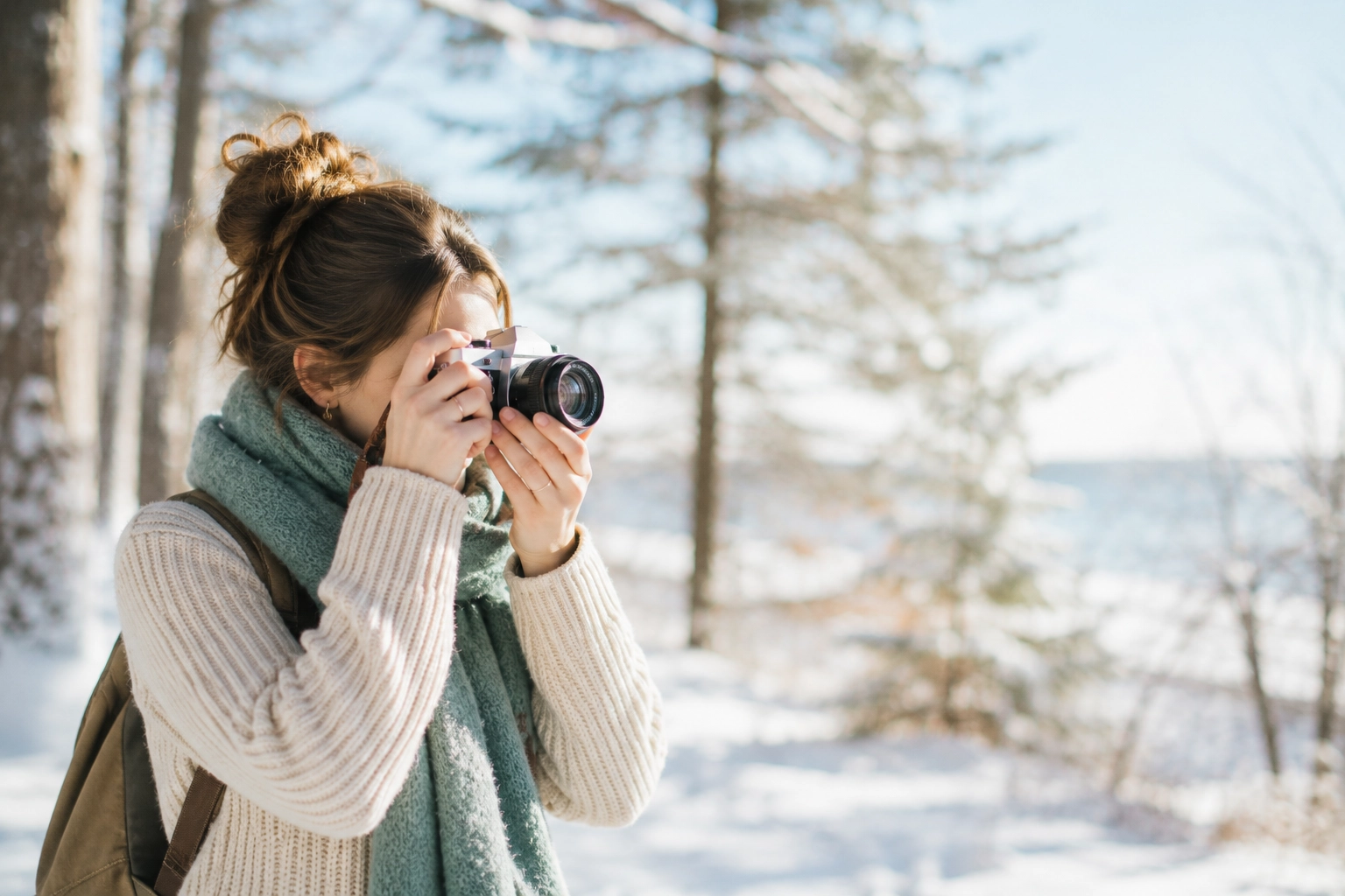 Film photographer taking a photograph outdoors in winter