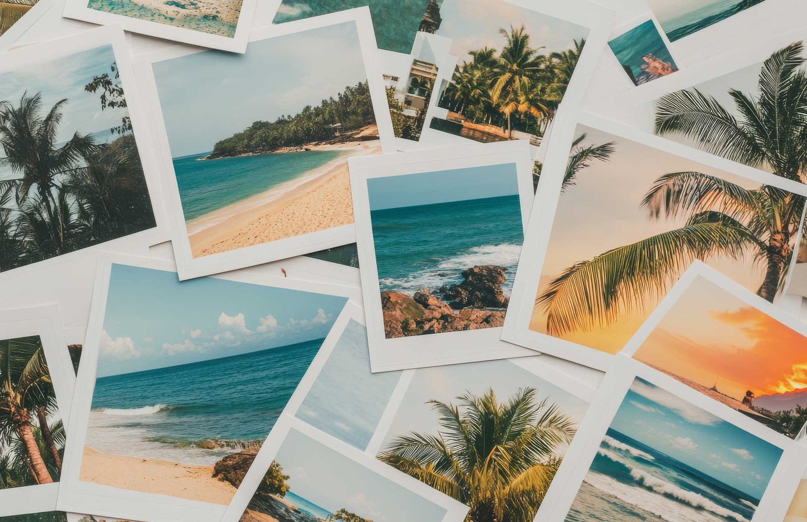Scattered prints of tropical beach landscapes featuring palm trees, ocean waves, and sandy shores