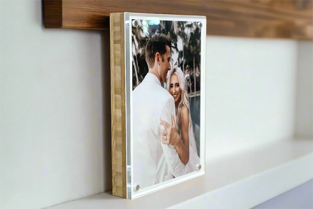 A custom acrylic photo print featuring a smiling couple in wedding attire, mounted on a wooden block and displayed on a shelf