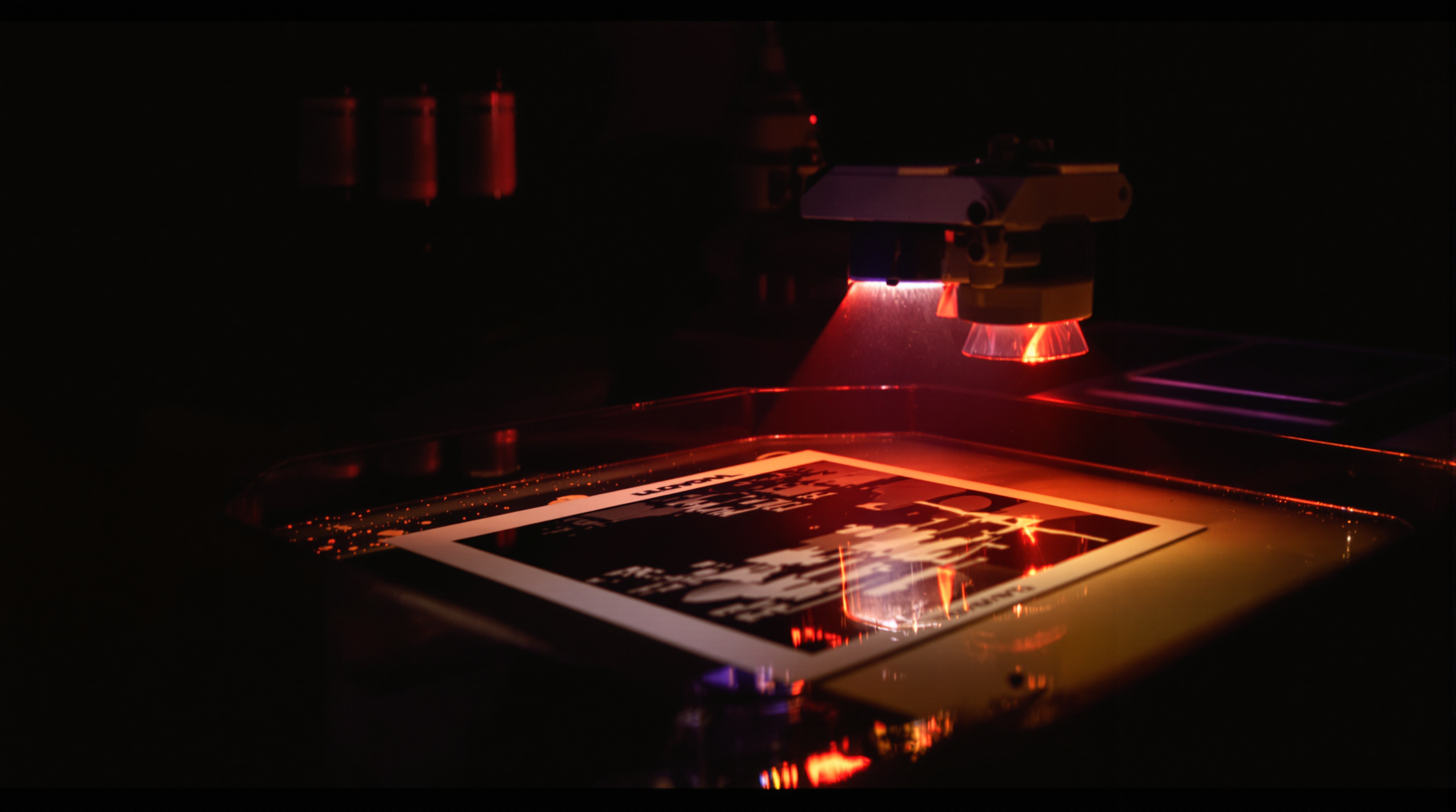 A photographer working in a dimly lit darkroom with red safelight illumination, hands carefully developing a black and white film print in a chemical tray. Close-up shows the image gradually appearing on the paper, with vintage film rolls, enlarger, and ch