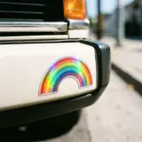 die cut holographic rainbow sticker on a car bumper