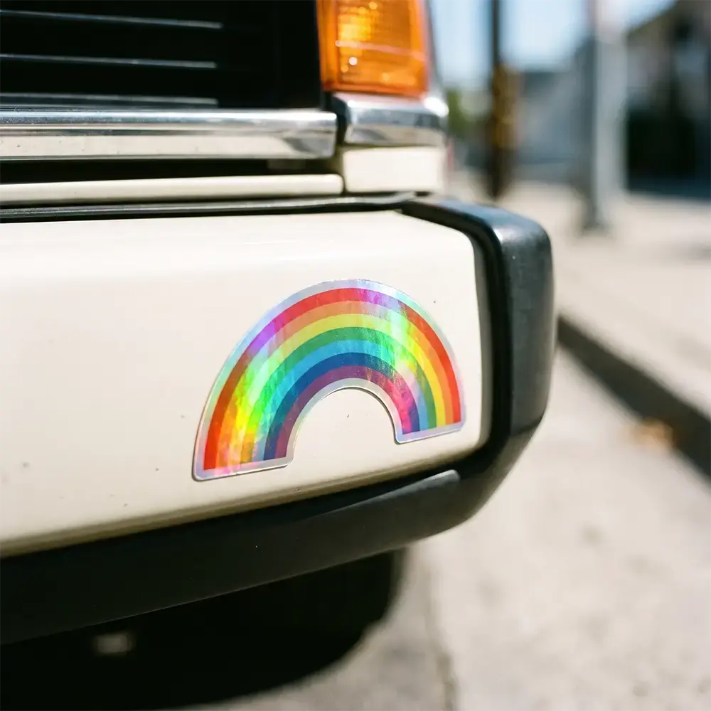 die cut holographic rainbow sticker on a car bumper