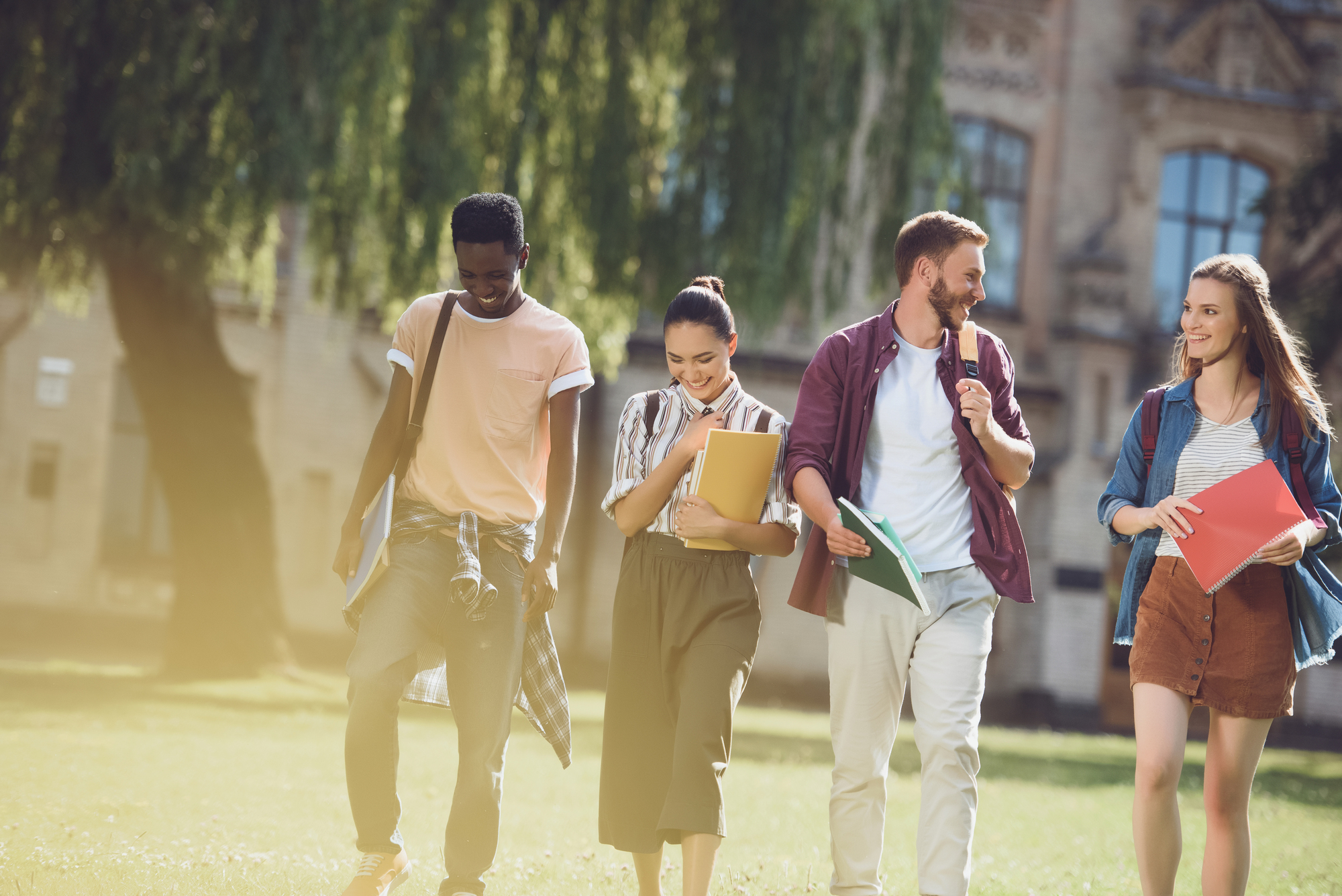 A group of four students walking across campus together.