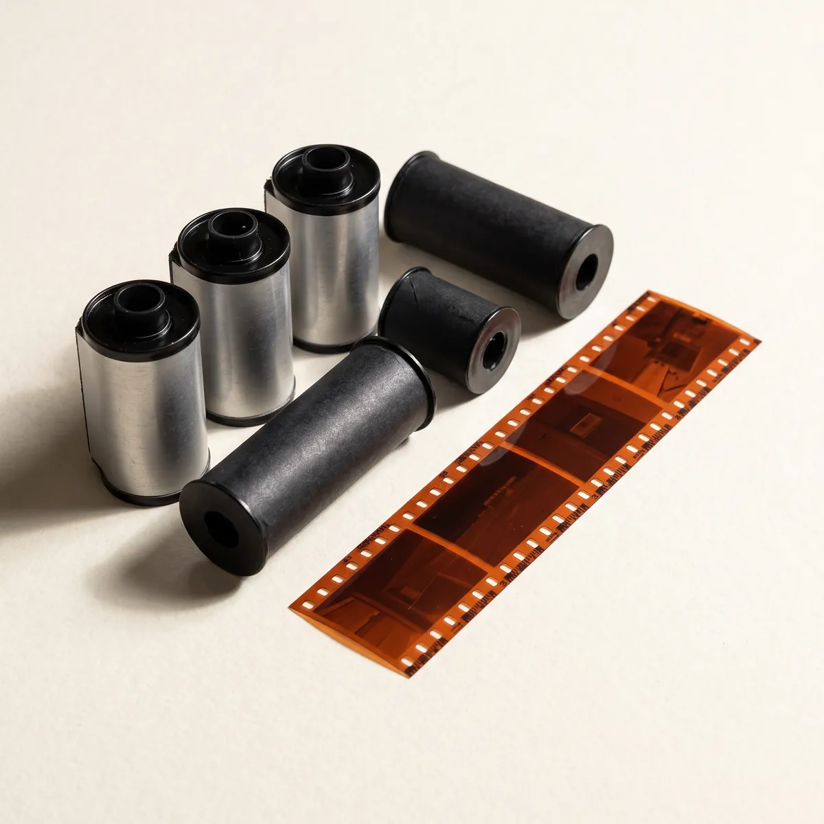 Rolls of 35mm and 120 film with a strip of developed color negatives.