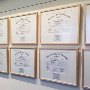 Framed professional certificates displayed in a business office wall gallery