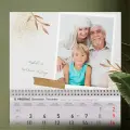 Personalizirani zidni kalendar s elegantnim zlatnim granama i efektom trake, idealan za obiteljske uspomene i posebne trenutke