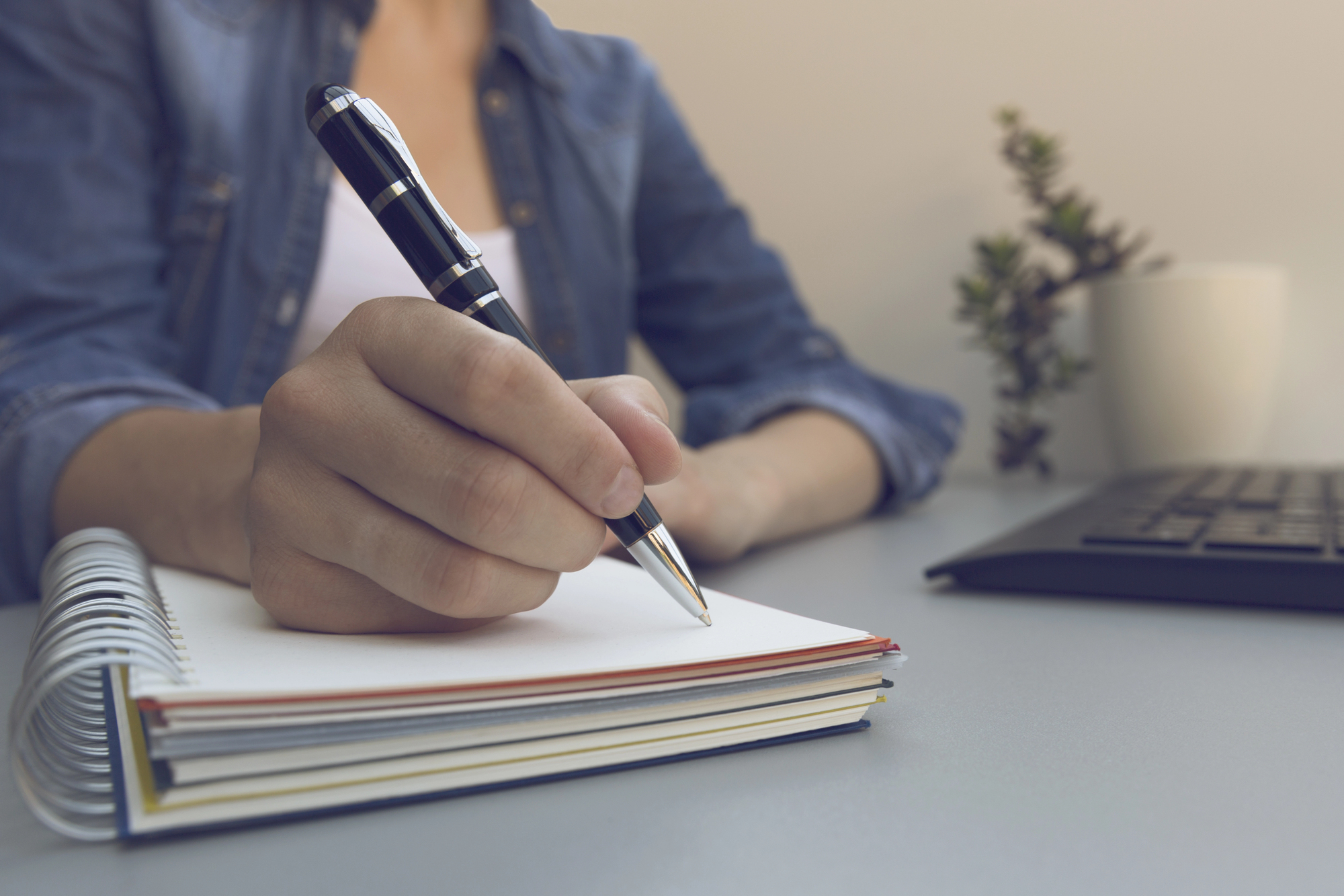 A close-up shot of a person beginning a journal entry at their desk.