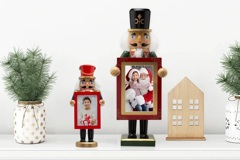 Two festive nutcracker photo frames holding holiday pictures, displayed on a shelf with mini Christmas trees and decorative accents