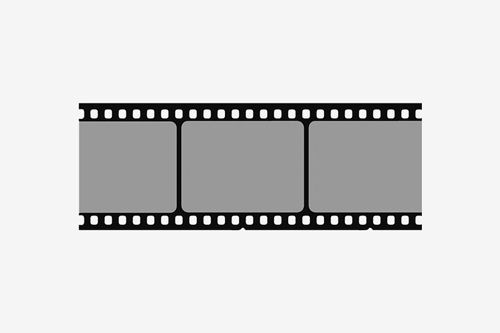 Close-up of photo film negatives and 35mm film rolls on a light gray surface, used for scanning or photo development services