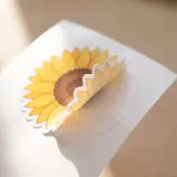 Die cut vinyl sunflower sticker half off the paper.   