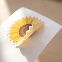 Die cut vinyl sunflower sticker half off the paper.   
