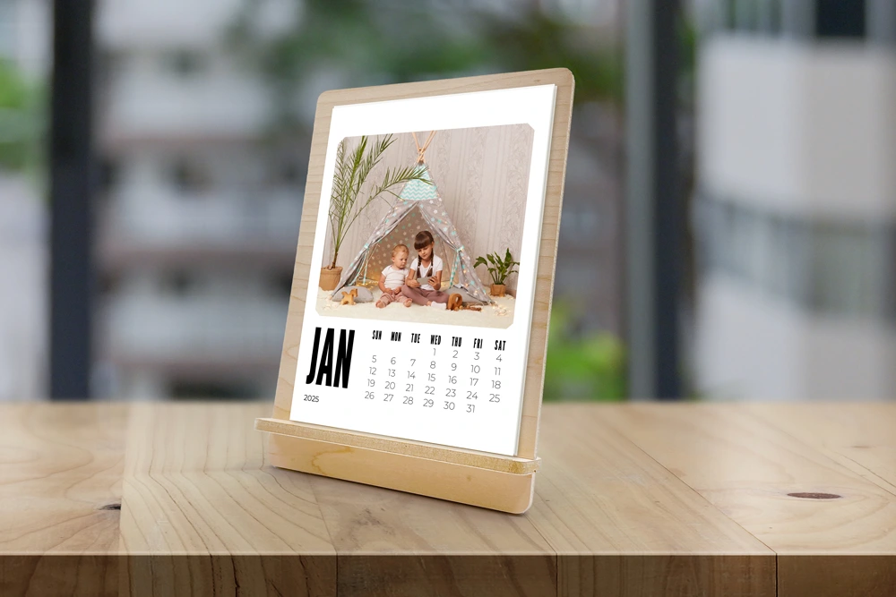 5x7 monthly photo calendar on a maple wood easel stand sitting on table