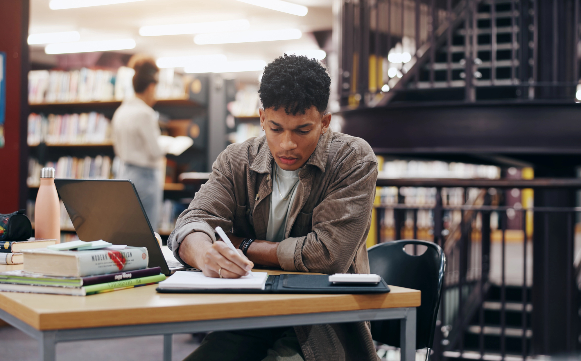 A student studying and doing homework in the library. 