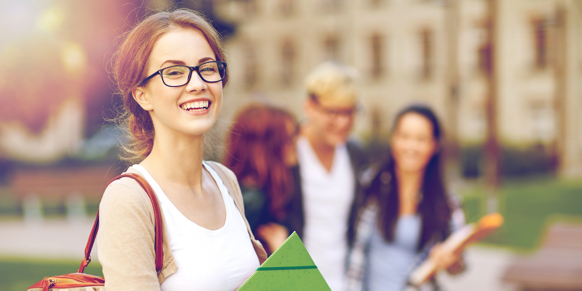 A student smiling while walking across campus.