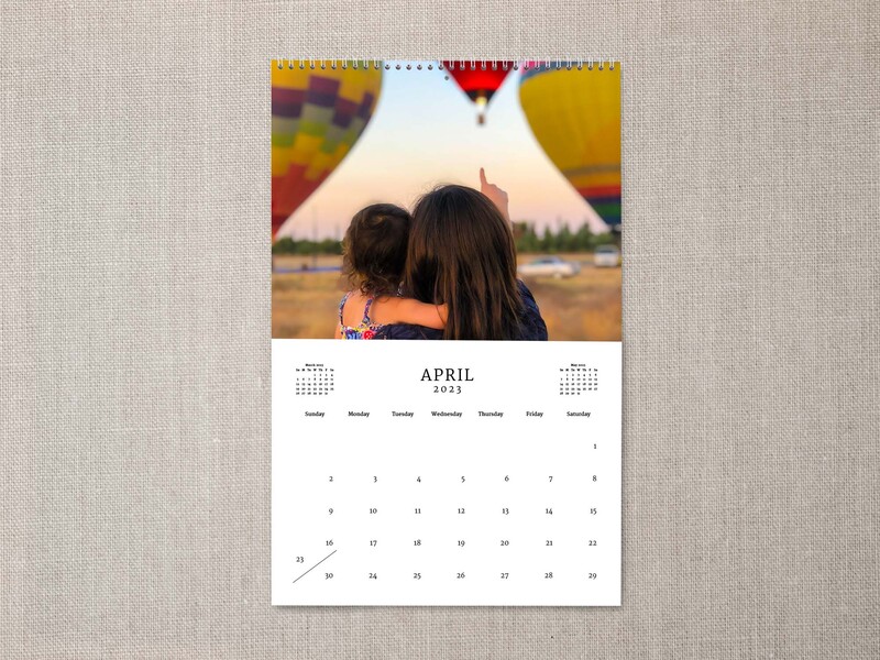 Personalized calendar with image of a mother carrying a child while watching hot air balloons