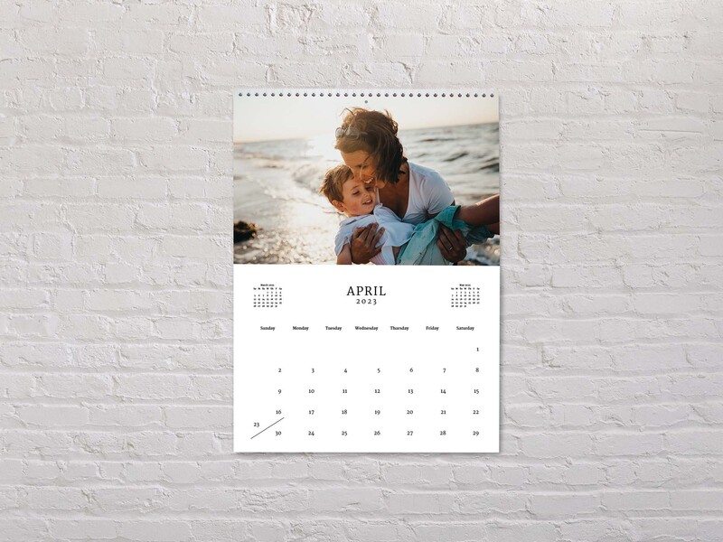 Photo Calendar image of young mother cuddling her toddler on the beach