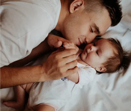 Father and baby boy lying in bed.